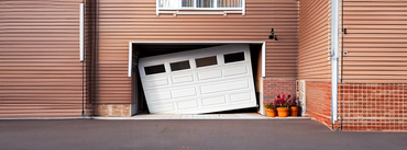 white residential garage door with broken torsion spring